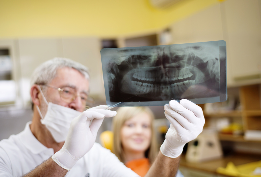 fotografia-de-dentista-mostrando-raiox-dos-dentes-para-paciente
